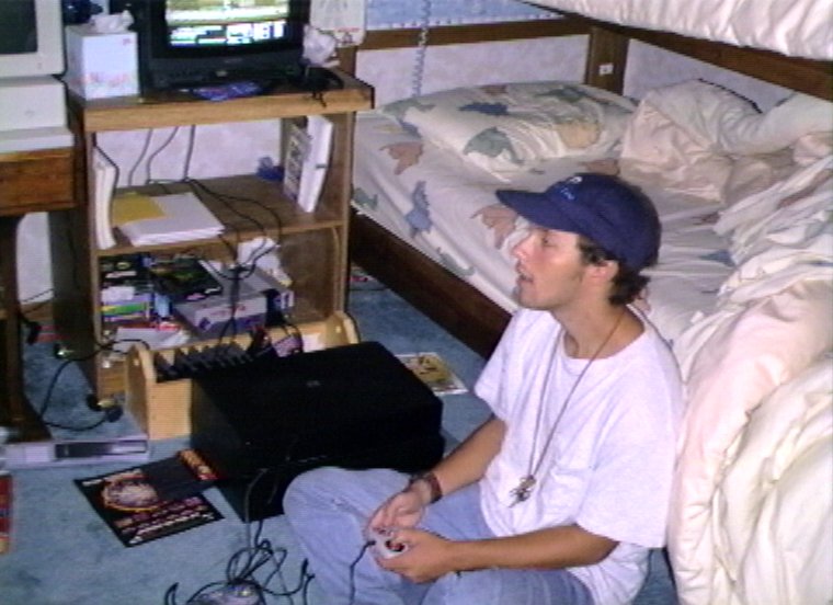 Plyc169.jpg - Mark Tuura playing computer games at Fozzie’s dads house.